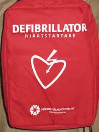 Röd väska med texten DEFIBRILLATOR HJÄRTSTARTARE