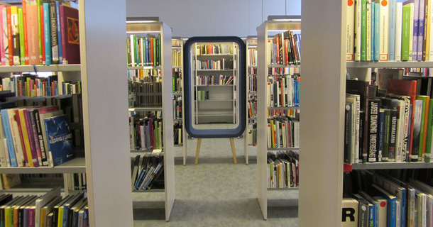 Bokhyllor och blå sittmöbel på Kungsörs bibliotek.