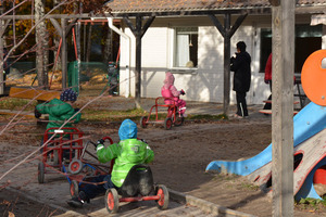 Barn som cyklar på trehjulingar utanför förskolan