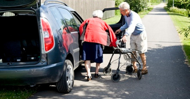 Bild på person med funktionsnedsättning som stiger in i en bil